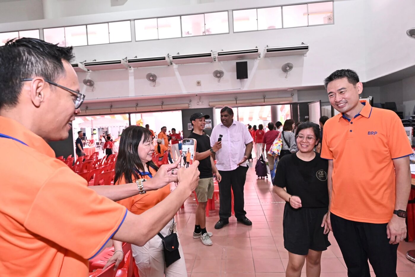 Guests taking photos with the LinkNow team at a People's Association Open House